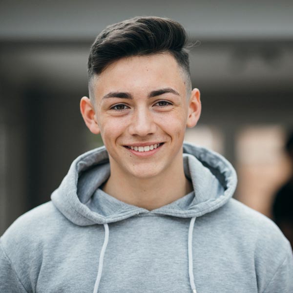 young man in gray hoodie smiling